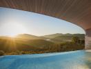 Luxurious infinity pool with panoramic mountain views at sunset