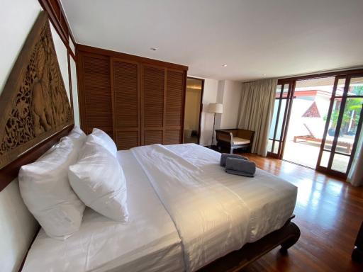 Spacious bedroom with wooden floors and art piece above the bed