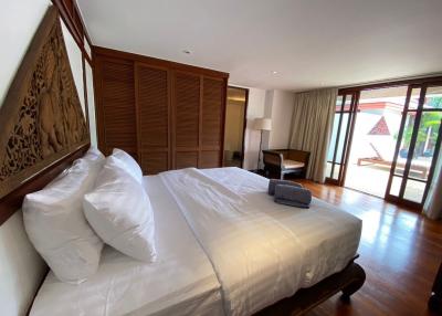 Spacious bedroom with wooden floors and art piece above the bed