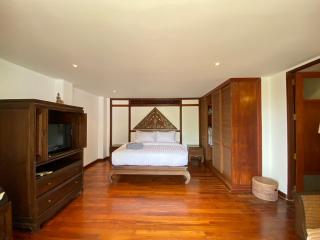 Spacious bedroom with hardwood floors and traditional decor