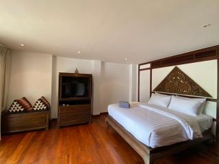 Spacious bedroom with wooden floor and traditional decor