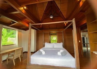 Cozy wooden bedroom with a large bed and natural lighting