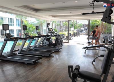 Modern gym in residential building with various equipment and residents exercising