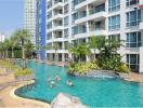 Residents enjoying the communal outdoor swimming pool in a modern apartment complex