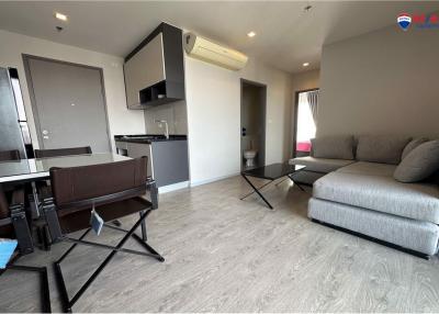 Modern apartment interior with open plan living space featuring a living area, dining area, and kitchenette