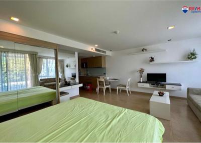 Modern bedroom with integrated living space, large windows, and open plan layout