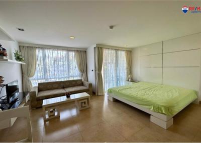 Spacious bedroom with combined living area featuring a large bed and a comfortable couch