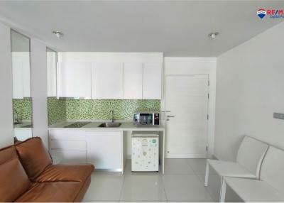 Modern kitchen with white cabinets and brown sofa