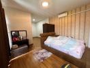 Cozy bedroom with wooden floor, large bed, and modern air conditioning unit