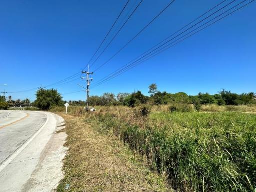 Vacant land next to a road under clear blue sky