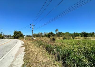 Vacant land next to a road under clear blue sky