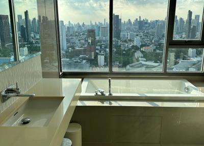 Modern bathroom with large windows overlooking the city skyline