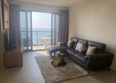 Spacious living room with a view of the sea through a large balcony door