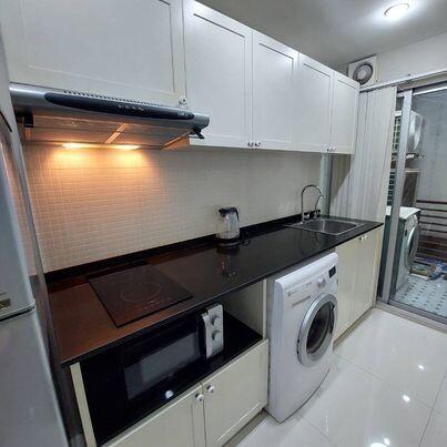 Modern kitchen with white cabinets, black countertops, and built-in appliances