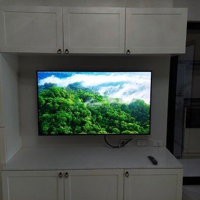 Modern living room with mounted television and white cabinetry