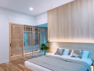 Modern bedroom with large bed, wooden accents, and balcony access