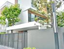 Modern residential building exterior with lush greenery