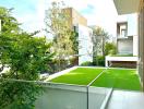 Spacious balcony with glass balustrade overlooking a green garden