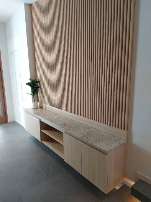 Modern living area with wooden slat wall design and a console table