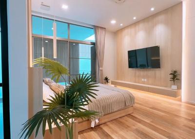 Modern bedroom with large window and hardwood flooring