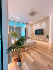 Modern bedroom with large window and hardwood flooring