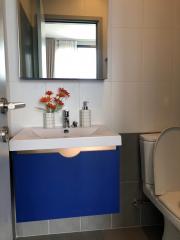 Modern bathroom with blue vanity and silver accessories