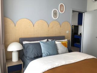Modern bedroom with stylish headboard and decorative wall hangings