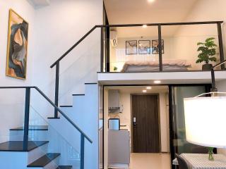 Modern open concept living space with staircase and mezzanine bedroom