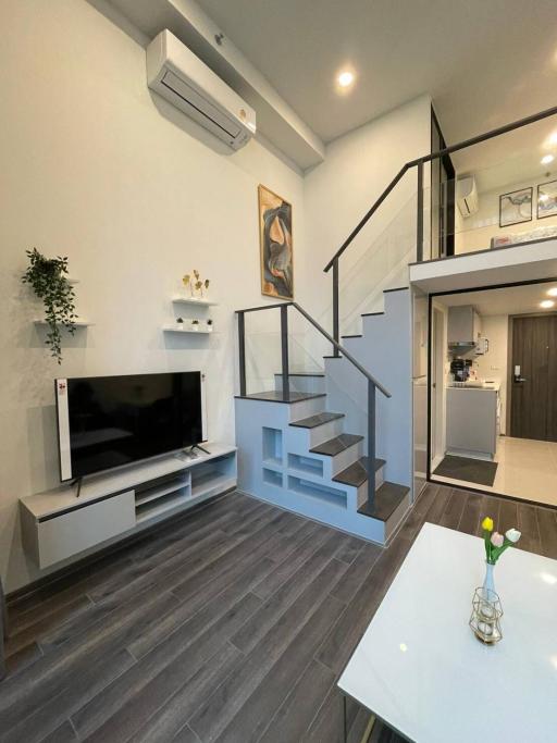 Modern living room with staircase and television