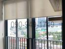 Modern balcony with a city view, transparent railings, and outdoor seating