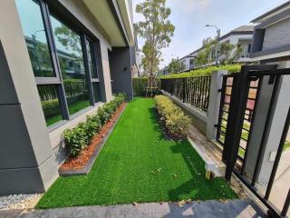 Well-maintained front yard of a modern house with artificial grass and a swing