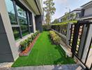 Well-maintained front yard of a modern house with artificial grass and a swing