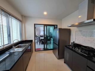 Modern kitchen with stainless steel appliances and an open layout to dining area