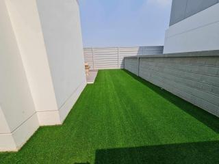 Spacious artificial turf backyard with high privacy walls