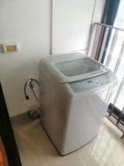 Compact laundry area with washing machine and tiled flooring