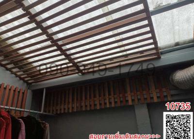 Patio area with a wooden slat roof allowing natural light