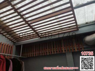 Patio area with a wooden slat roof allowing natural light