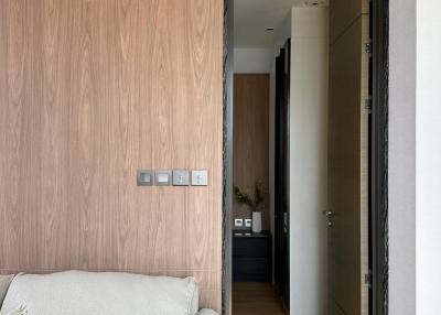 Modern living room with elegant wooden wall and view into hallway