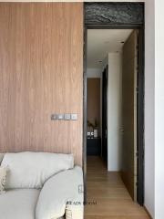 Modern living room with elegant wooden wall and view into hallway