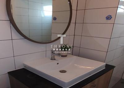 Modern bathroom interior with ceramic sink and round mirror