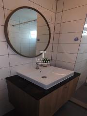 Modern bathroom interior with ceramic sink and round mirror