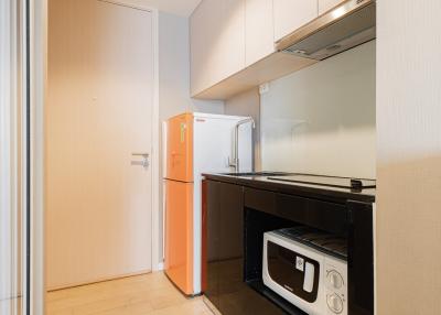 Compact Kitchen with Orange Refrigerator and Black Appliances