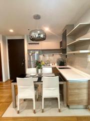 Modern kitchen with dining area, stainless steel appliances, and sleek cabinetry