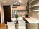 Modern kitchen with dining area, stainless steel appliances, and sleek cabinetry