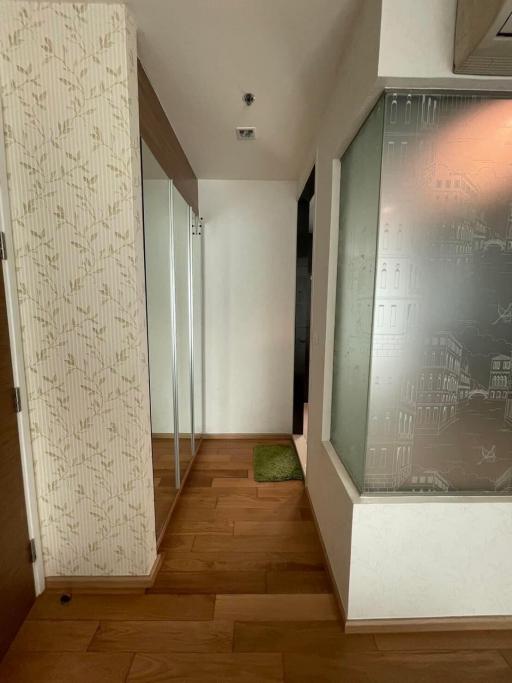 Compact hallway with wooden flooring and decorative wall panel