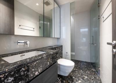 Modern bathroom with marble countertops and glass shower