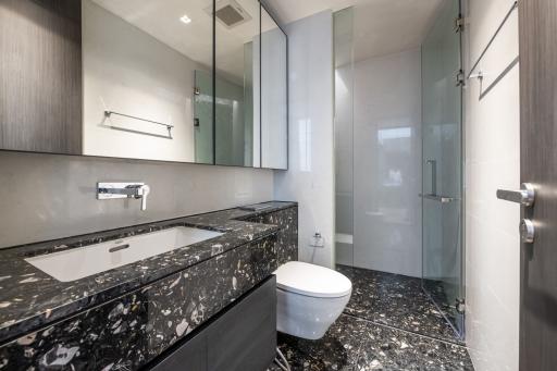 Modern bathroom with marble countertops and glass shower