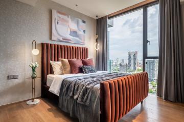 Modern bedroom with king-size bed and city view through large windows