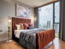 Modern bedroom with king-size bed and city view through large windows