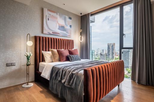 Modern bedroom with king-size bed and city view through large windows